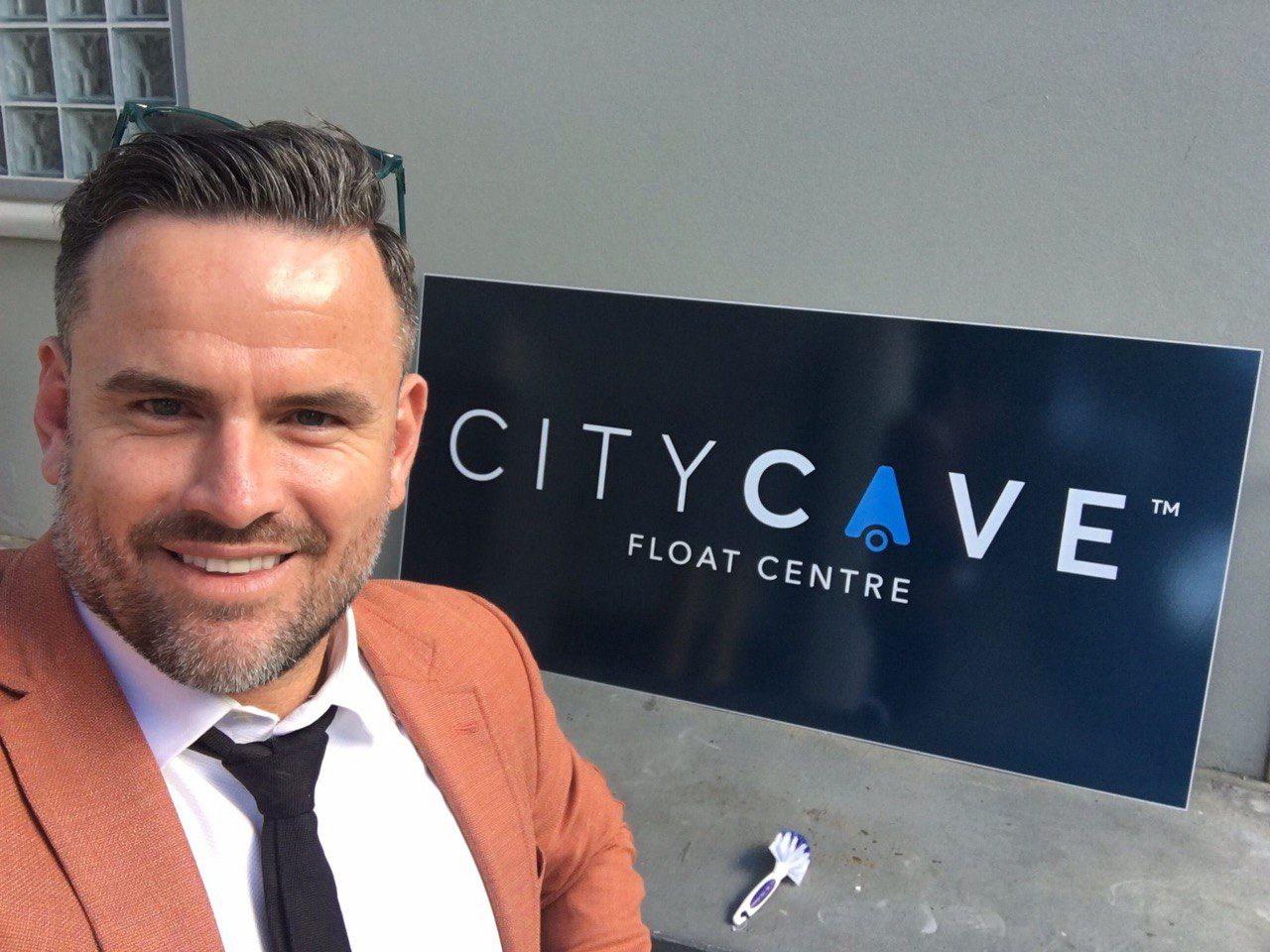 Shane Williams beside the newly installed City Cave Float Centre sign.